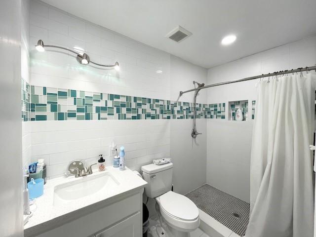 bathroom with vanity, toilet, and walk in shower