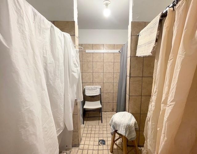 bathroom featuring curtained shower and tile walls