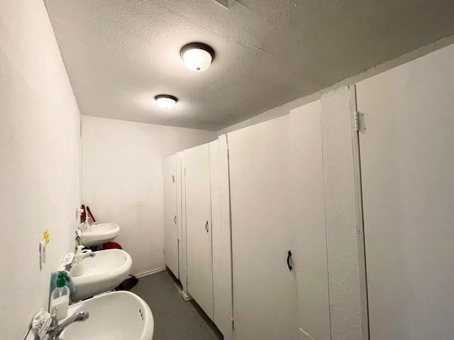 bathroom featuring a textured ceiling, sink, and a bidet