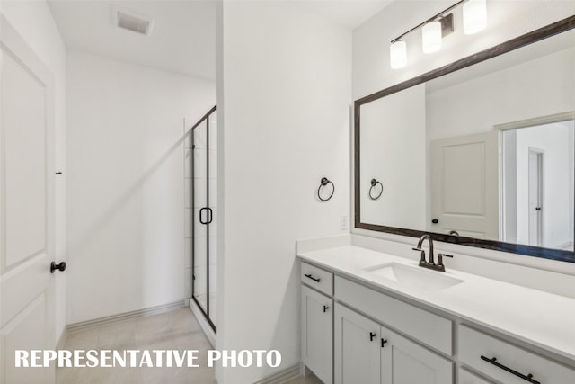 bathroom featuring tile patterned flooring, vanity, and a shower with shower door