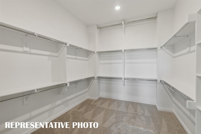 walk in closet featuring light colored carpet