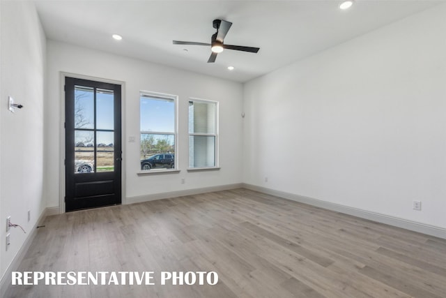 unfurnished room with ceiling fan and light wood-type flooring