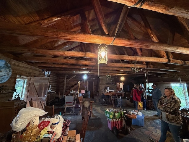 interior space with log walls and vaulted ceiling with beams