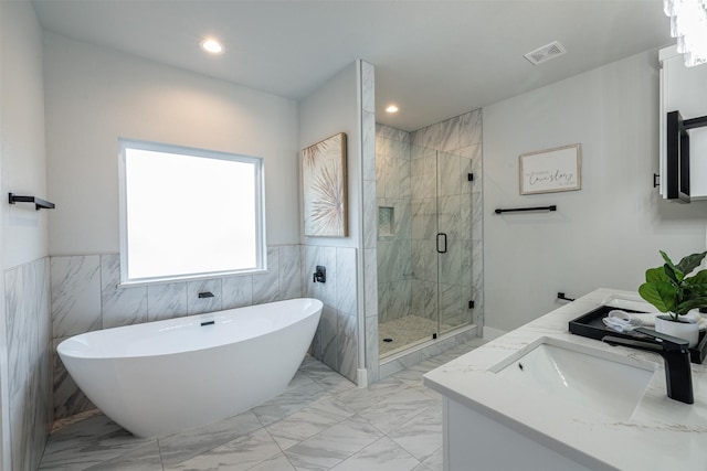 bathroom featuring vanity, separate shower and tub, and tile walls