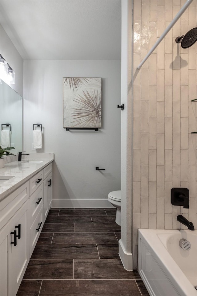 full bathroom featuring vanity, tiled shower / bath combo, and toilet