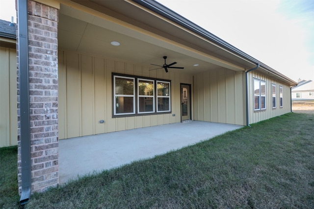 rear view of property featuring a yard, a patio, and ceiling fan