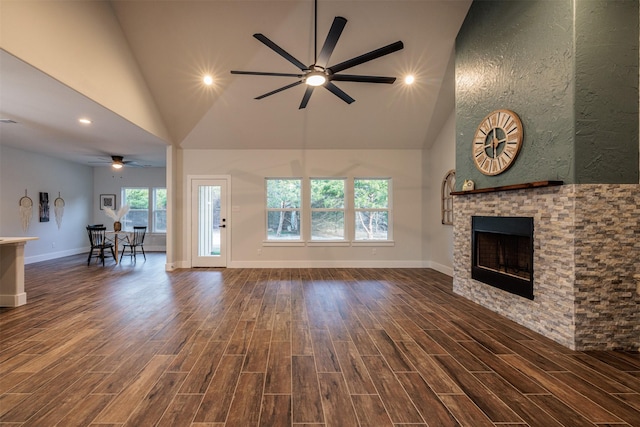 unfurnished living room with a fireplace, high vaulted ceiling, and ceiling fan