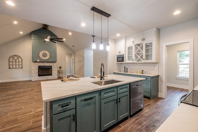 kitchen featuring light stone counters, a kitchen island with sink, sink, dishwasher, and white cabinetry