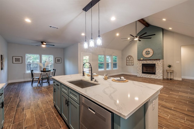 kitchen featuring a fireplace, sink, pendant lighting, a center island with sink, and dishwasher