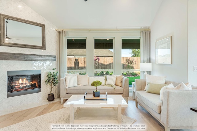 sunroom / solarium with ceiling fan, a fireplace, and vaulted ceiling