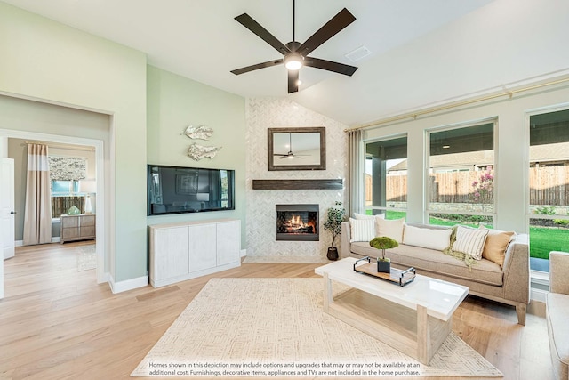 living room featuring light hardwood / wood-style floors, a wealth of natural light, lofted ceiling, and ceiling fan