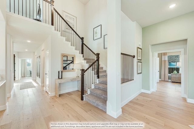 stairway featuring hardwood / wood-style floors and a high ceiling