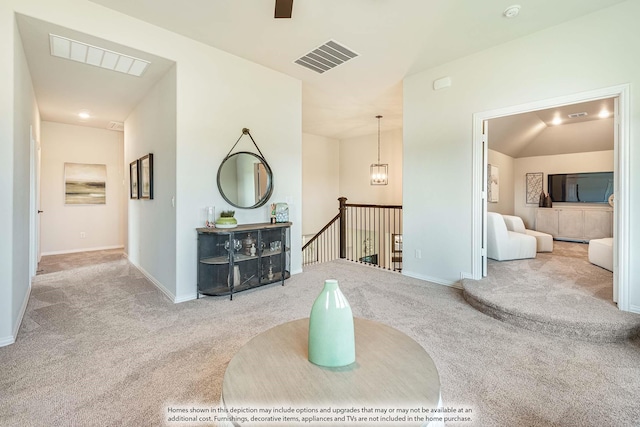 hallway with light carpet and lofted ceiling