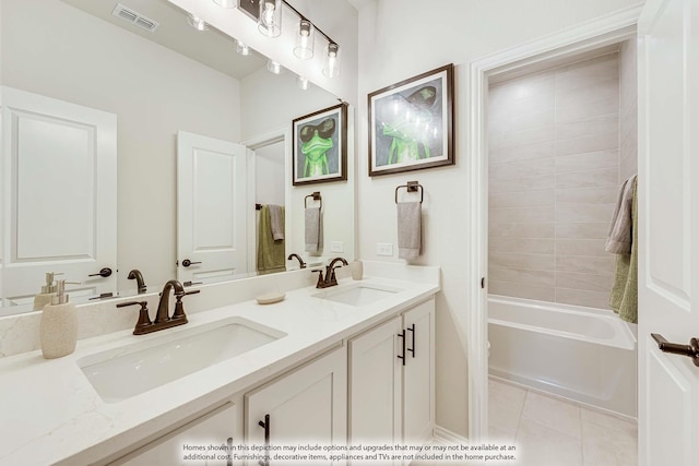 bathroom with tile patterned flooring, vanity, and tiled shower / bath combo