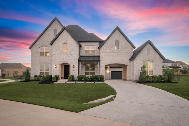 french country inspired facade with a garage and a lawn