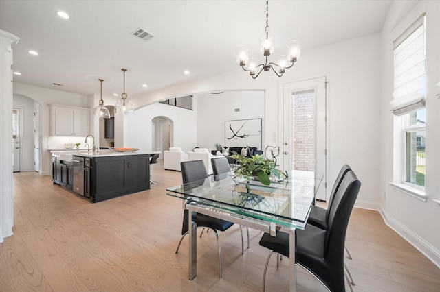 dining room featuring a notable chandelier, light wood-type flooring, and sink