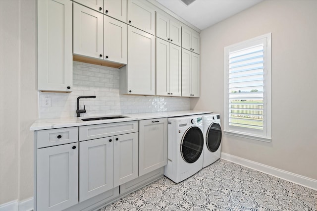 washroom with cabinets, sink, and washer and dryer