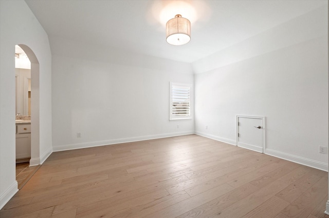 unfurnished room with light hardwood / wood-style floors and sink