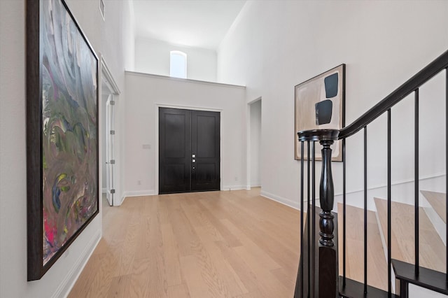 entryway with a high ceiling and light wood-type flooring