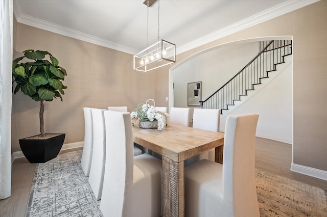 dining space featuring a notable chandelier, crown molding, and light hardwood / wood-style flooring