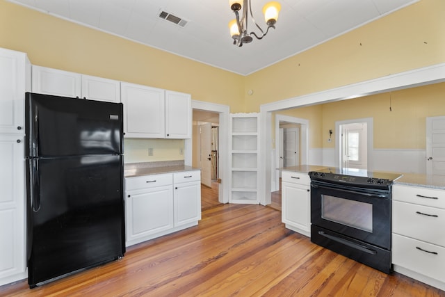 kitchen with light hardwood / wood-style floors, black appliances, an inviting chandelier, hanging light fixtures, and white cabinets