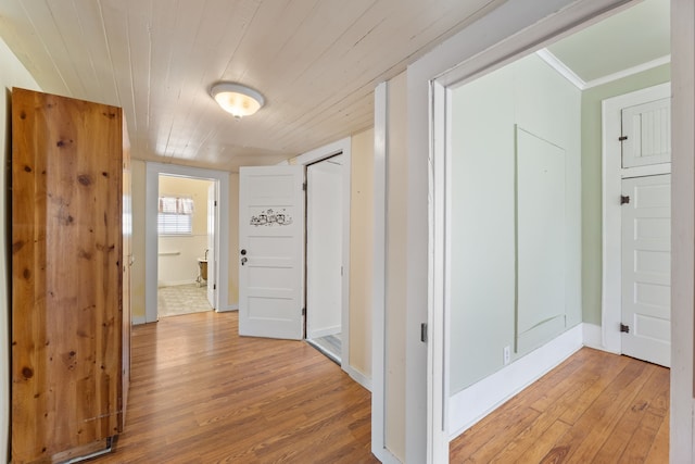 corridor with crown molding and light hardwood / wood-style floors