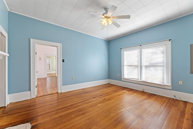 empty room featuring ceiling fan, wood-type flooring, and crown molding