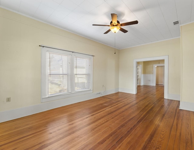 empty room featuring ceiling fan, crown molding, and hardwood / wood-style flooring