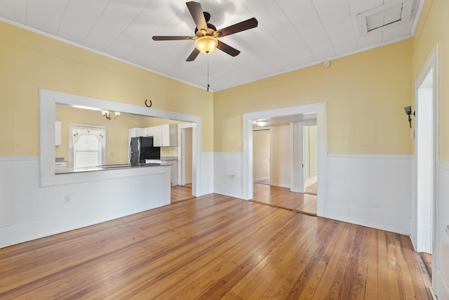 unfurnished living room featuring light wood-type flooring, ceiling fan, and ornamental molding