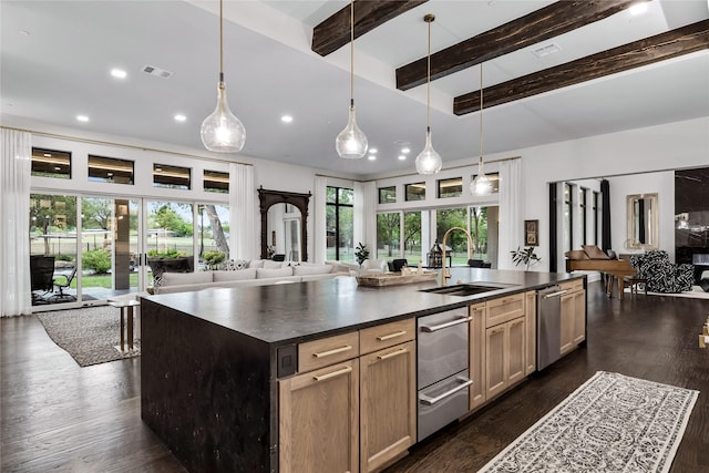 kitchen featuring sink, pendant lighting, a center island with sink, beamed ceiling, and dark hardwood / wood-style floors