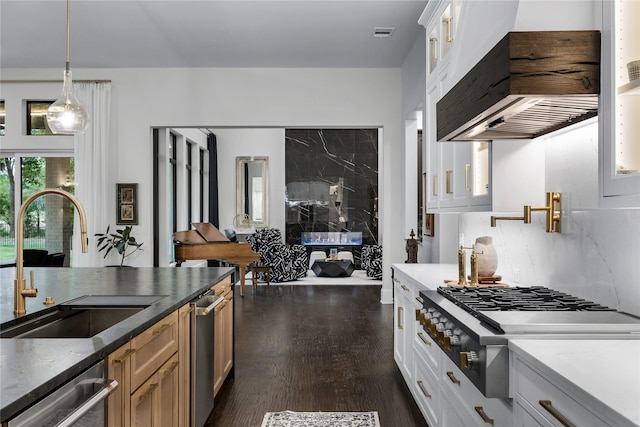 kitchen featuring white cabinetry, sink, tasteful backsplash, pendant lighting, and appliances with stainless steel finishes