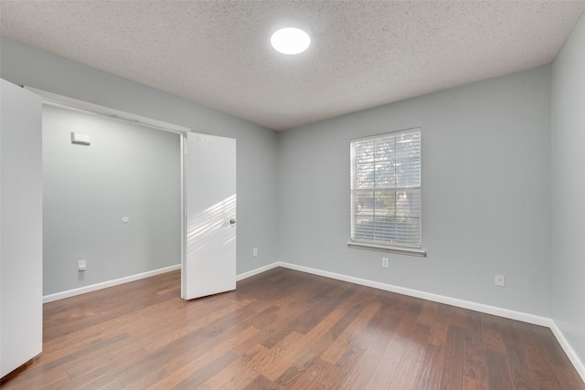 unfurnished room featuring a textured ceiling and hardwood / wood-style floors