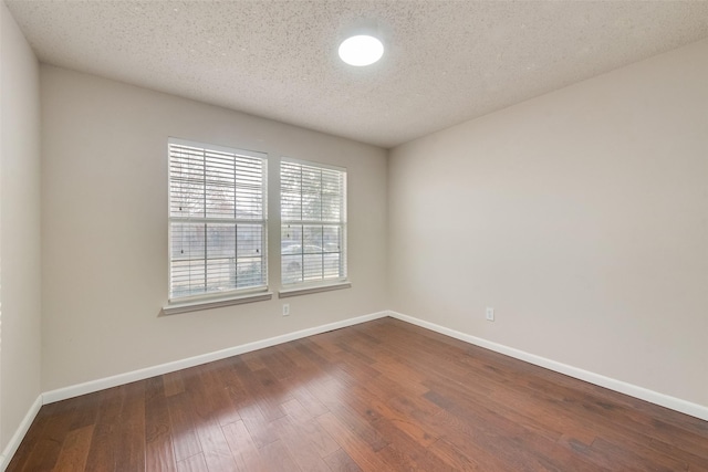 spare room featuring a textured ceiling and wood-type flooring