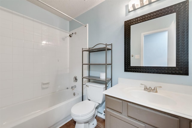 full bathroom with toilet, a textured ceiling, hardwood / wood-style floors, tiled shower / bath combo, and vanity