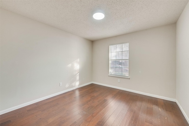 empty room featuring a textured ceiling and hardwood / wood-style flooring