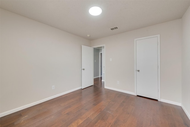 unfurnished bedroom featuring dark hardwood / wood-style flooring