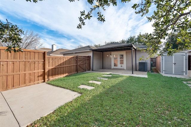 view of yard featuring french doors, a patio, central AC unit, and a shed