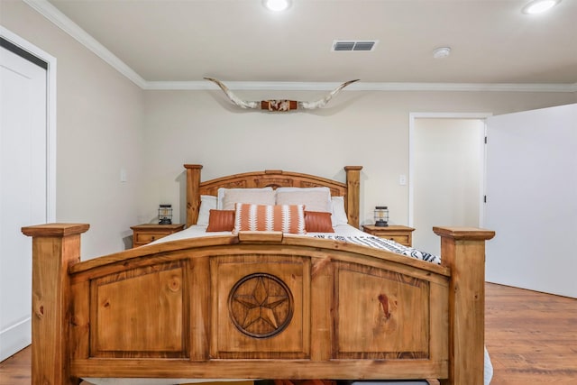 bedroom with crown molding and hardwood / wood-style flooring