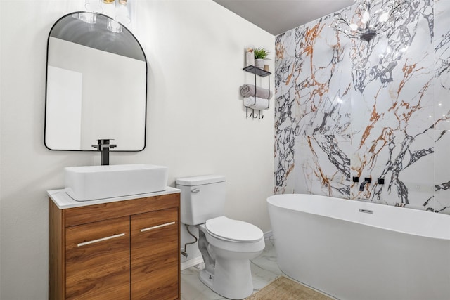 bathroom with vanity, toilet, and a tub