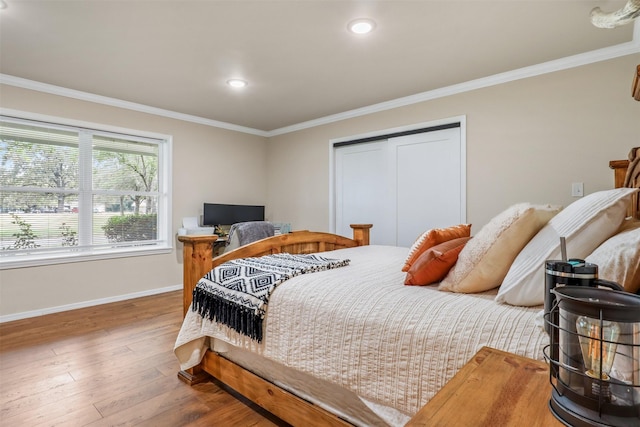 bedroom with a closet, ornamental molding, and hardwood / wood-style flooring