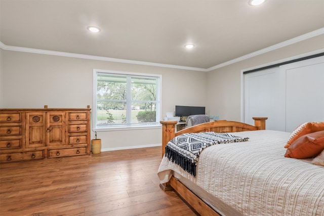 bedroom featuring a closet, hardwood / wood-style floors, and ornamental molding