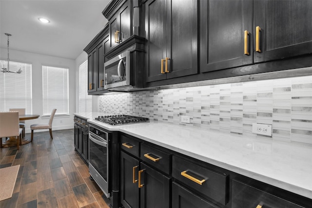 kitchen with decorative light fixtures, decorative backsplash, and appliances with stainless steel finishes