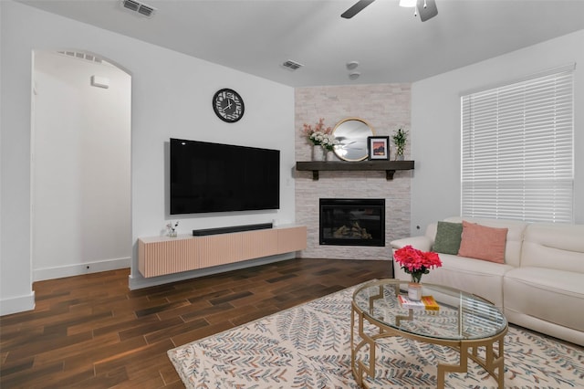 living room featuring ceiling fan and a large fireplace