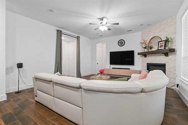 living room with a large fireplace and ceiling fan