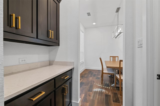 kitchen with light stone countertops and dark brown cabinetry