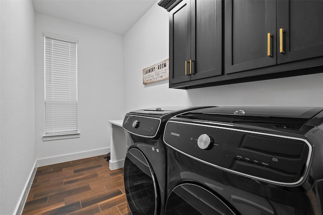 clothes washing area featuring cabinets and separate washer and dryer