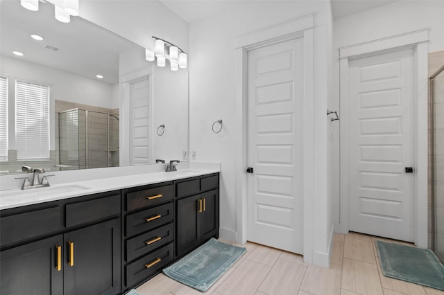 bathroom featuring tile patterned flooring, vanity, and an enclosed shower