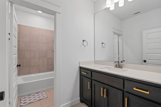 bathroom featuring tile patterned flooring, vanity, and tiled shower / bath combo