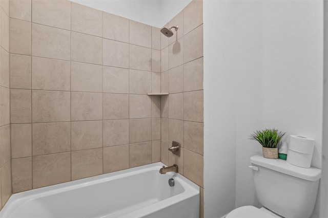 bathroom featuring tiled shower / bath combo and toilet