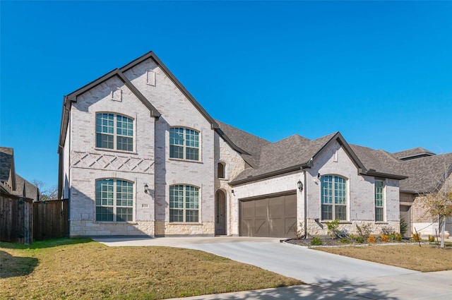 french country home featuring a garage and a front yard